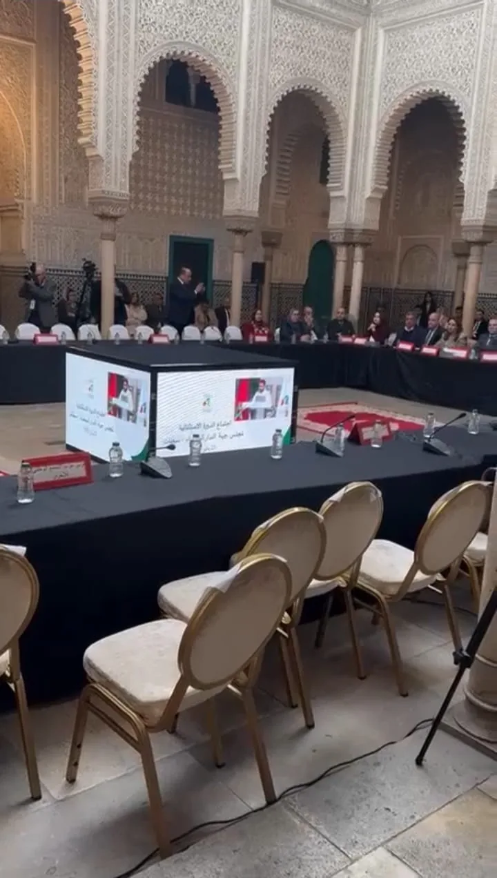 Microphones de table et écrans installés pour une réunion institutionnelle dans la cour d'un riad